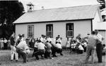 Two groups of men participate in a tug-of-war at the Pinegrove School reunion