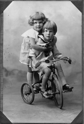 Boy and girl on tricycle