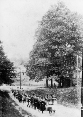 School children carrying chairs up Prince Street 1918