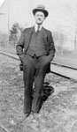 Man standing beside a rail line.