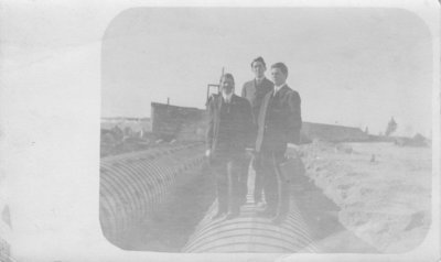 Men standing on culvert