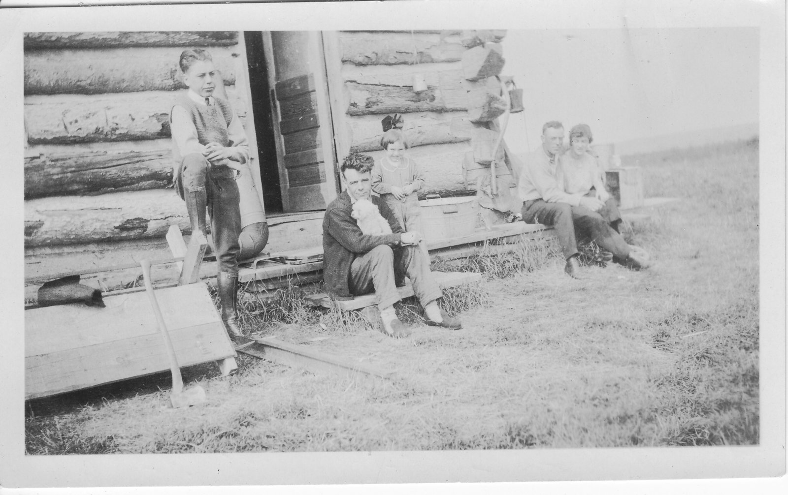Group of people sitting by log cabin
