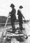 Two men men standing on raft in small lake near Otter Cove.