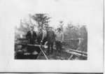 Group of men building log cabin