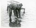 Man releasing fish into water, Thessalon Township, Circa 1995