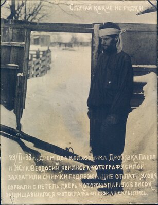 Nikolai Bokan stands beside the broken gate to his property, vandalized by debtors who would not pay him for his photography services.