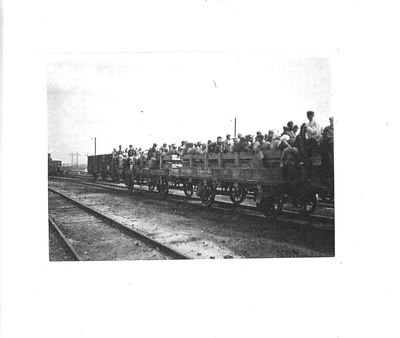 Workers in open railway carts are returning from their shift at industrial building sites near the Dnipro Hydroelectric dam