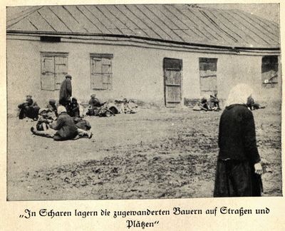 Families from the starving countryside rest near a low-lying building on the outskirts of Kharkiv