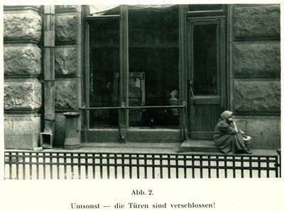 A woman sits on the doorstep of an unidentified establishment in Kharkiv