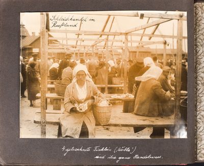 Woman with a handful of small fish at an open-air marketplace in Kharkiv