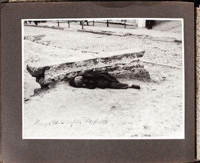 A famine victim lies dead against a cement barrier in Kharkiv