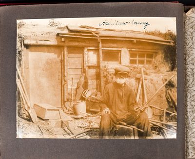 An elderly man sits in front of his hut on the outskirts of Kharkiv