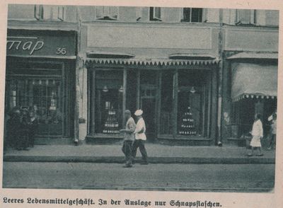 Two men walk by a store in Kharkiv with liquor bottles displayed in the window