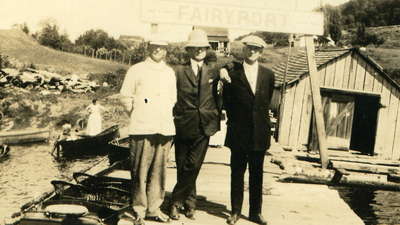 Fairyport dock, Fairy Lake, Huntsville, Ontario, with three Llwyd brothers standing in front of the Fairyport sign.