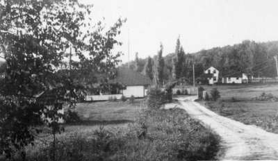 Road into Fairyport, Fairy Lake, Huntsville, Ontario, showing the entrance gateway and the farmhouse on right. 1934.