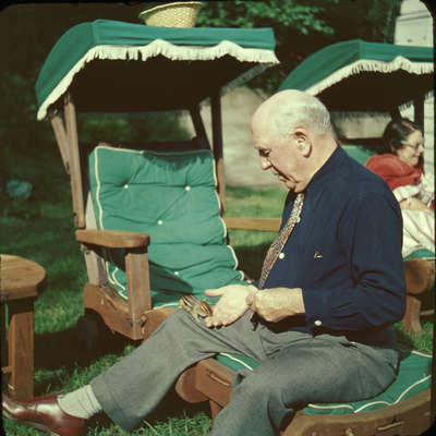 Dr. Edgar Evans, feeding a chipmunk, Huntsville, Ontario, 1951.  Wife Hilda in background.