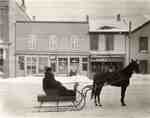 Man in horse-drawn sleigh on King St., Waterloo, Ontario