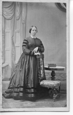 Portrait of an unidentified lady standing beside and leaning on a Chair, London, Ontario