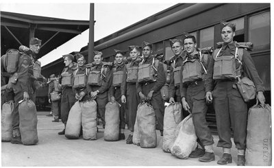 World War II:  Unidentified group of soldiers with army packs and gear at train station, London, Ontario