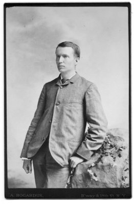 Portrait of unidentified young man standing by ivy covered rock in the photography studio of A. Bogardus, New York