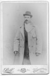 Portrait of mustached man in light overcoat