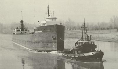 JAMES E. FERRIS is towed through the Homer Bridge by SALVAGE MONARCH and HELEN M. McALLISTER.