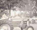 Man driving tractor in Centennial Parade in Milton