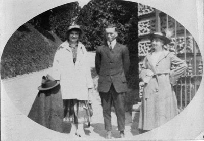 Man and two women standing by building