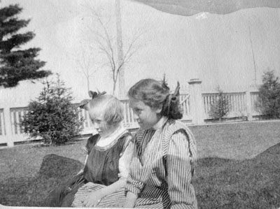 Woman and young girl seated on grass