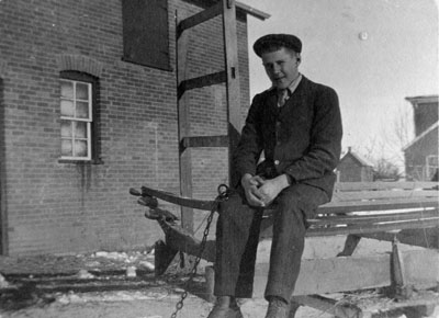 Man in dark suit and cap