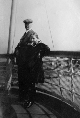 Man and girl posed on rail of ship