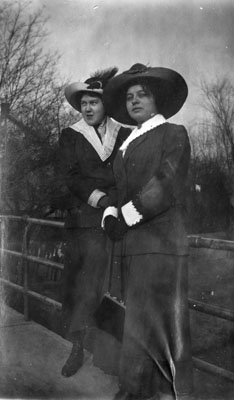 Two young ladies leaning against rail