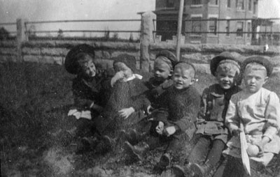 Young lady with five little children sitting in a row