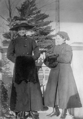 Woman and young lady posed outdoors