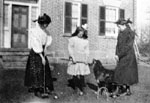 Three young women and dog engaged in croquet game