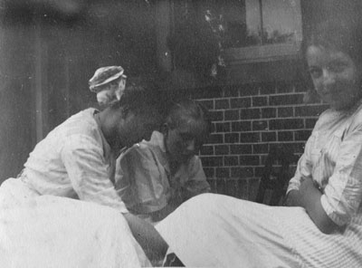 Three women seated on porch