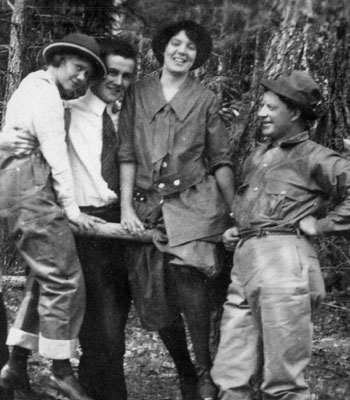 Two women and two men posed by fence