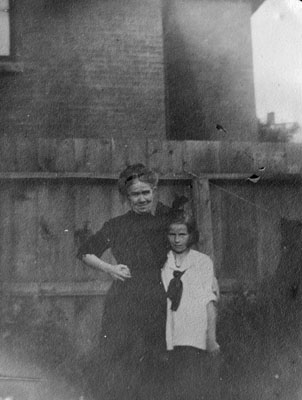 Woman and young girl standing by fence