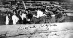 Seven young ladies posed behind stone wall