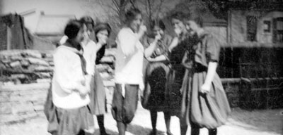 Seven girls posed by stone walls