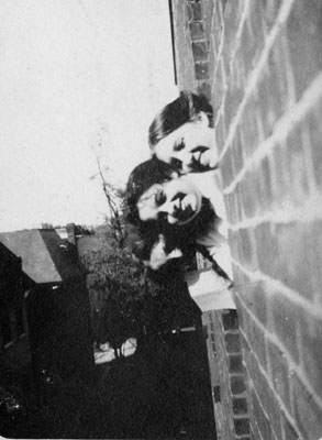 Two young ladies looking out of window