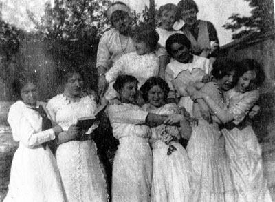 Eleven women in white dresses