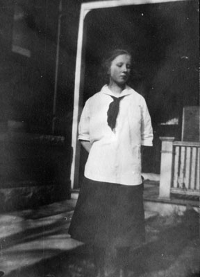 Adolescent girl posed by porch