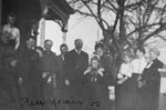 Family group posed outside house