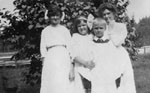 Three women and one boy dressed in white