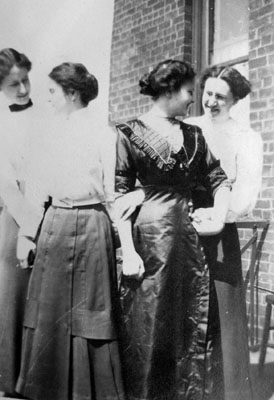 Four young ladies posed by brick building