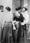 Four young ladies posed by brick building