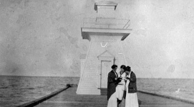 Three women posed by lighthouse