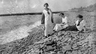 Three women on shore of lake