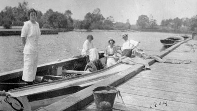 Three women and man in row boat